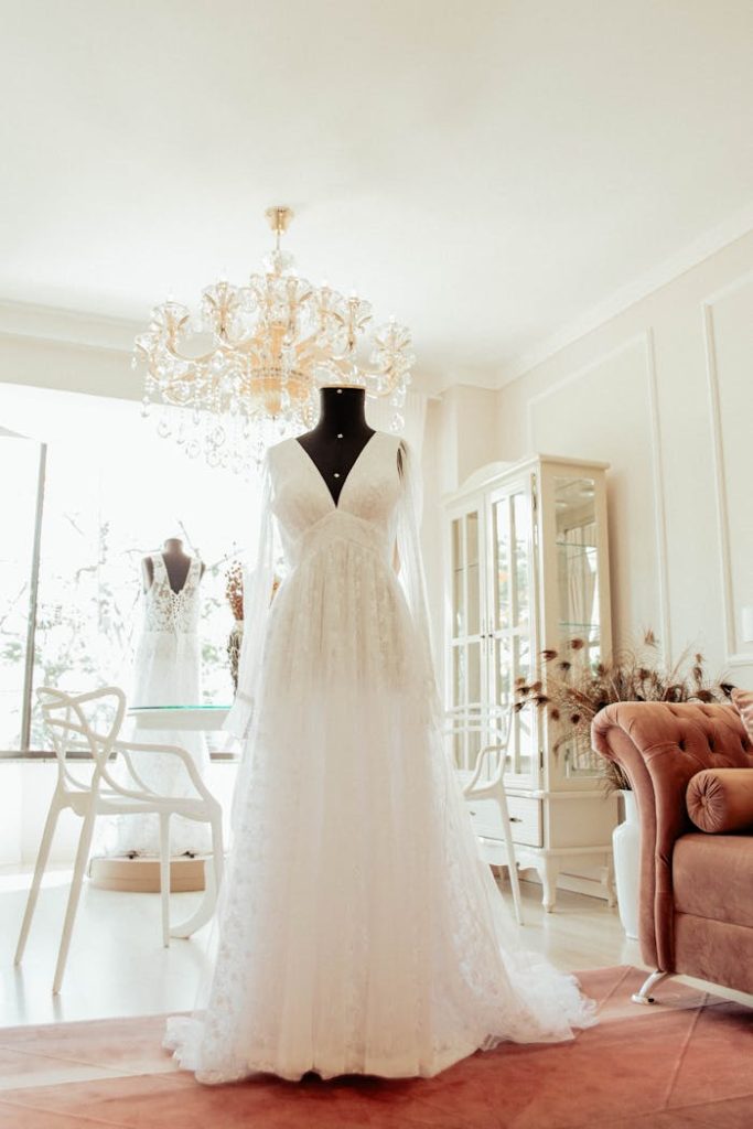 A beautifully crafted bridal gown displayed on a mannequin in a chic showroom with elegant decor.